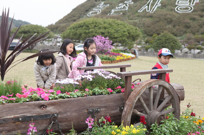 행사 준비가 한창인 가운데 행사장을 찾아온 어린이들이 꽃을 보며 즐거워하고 있다.
