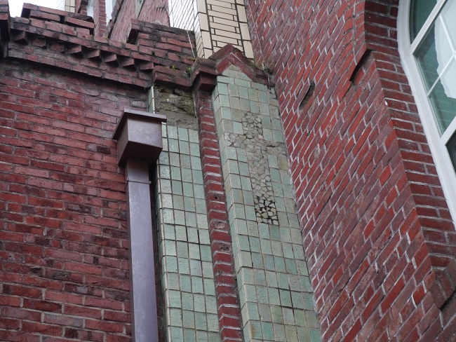 정문 옆 건물 벽에 색깔과 벽돌의 모양을 달리 해서 새겨 놓은 십자가 모양.