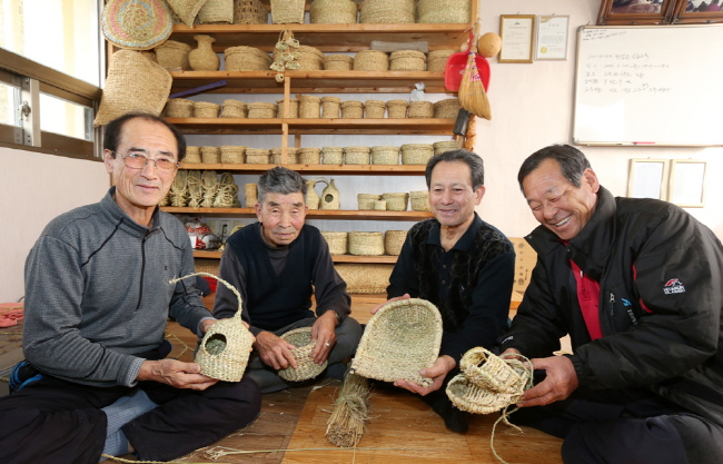 서산시 고북면 정자2리 경로당에서 마을 어르신들이 직접 만든 짚풀공예 작품들을 들고 환하게 웃고 있다.