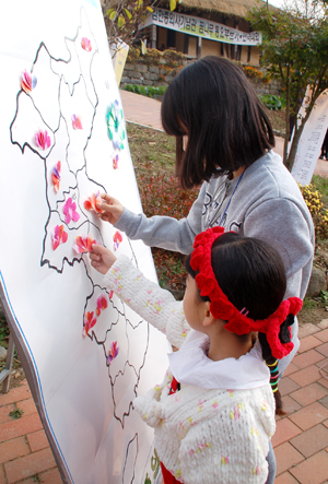 어린이들이 한반도 지도에 종이로 만든 나라꽃 무궁화를 붙이고 있다. ⓒ 무한정보신문