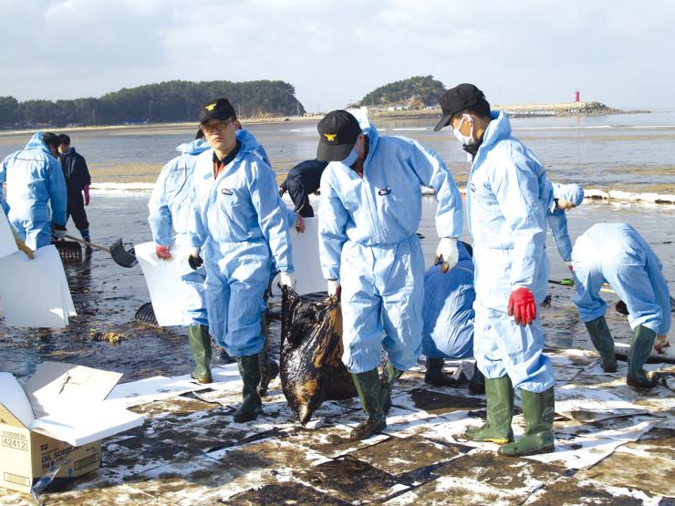 허베이 스피리트호 유류오염 사고가 발생한 지난 2007년 당시 소방공무원들이 인근 연안에 집결해 기름 떼 제거 작업에 힘을 모으고 있다.
