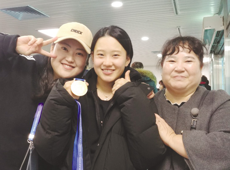 최민아사진 가운데 선수가 어머니사진 오른쪽와 코치와 함께 금메달 획득 후 기념촬영을 하고 있다.