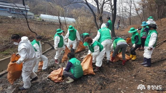 화재 로 인한 잔해을 치우는 아산시 새마을 지도자들의 모습