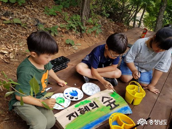 태안 근흥초 학생들이 자신들이 만든 '지혜의 숲' 현판에 예쁜 색칠을 하고 있다.   
