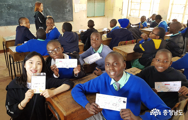 이수라 학생과 나이로비의 대이스프링 주니어 아카데미 학생들이 직접 만든 이름표를 들고 기념사진을 찍고 있다.