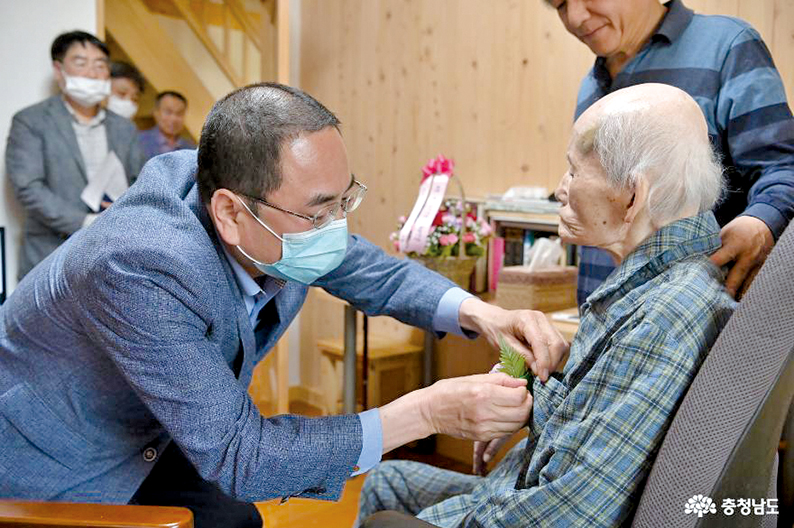어버이날을 맞아 이존관 공주시 부시장이 어르신에게 커네이션을 달아드리고 있다.