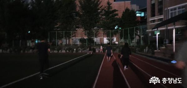 야간에 학교 운동장을 이용해 운동하는 시민들의 모습	 