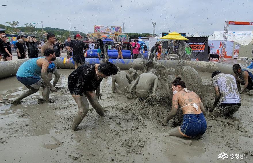보령해양머드박람회 머드플레이 경기에서 승리한 팀이 패배한 팀에게 진흙탕 물을 뿌리고 있다.