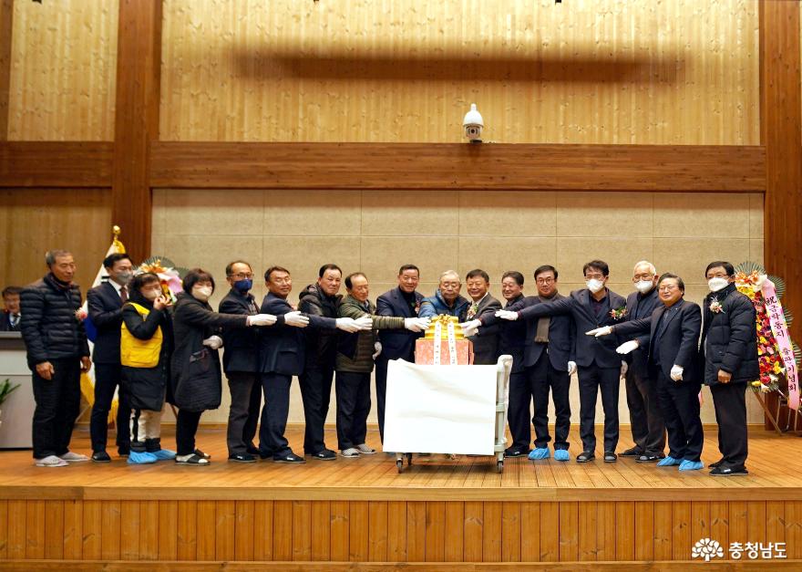기관, 단체장, 동민이 한자리에 모여 『금학동지』축하 기념떡을 절단하고 있다.