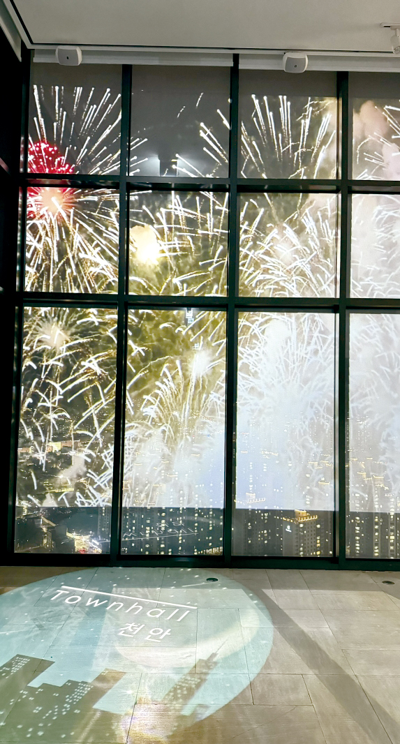 특수 필름을 부착한 유리 벽면을 통해 천안시의 야경과 불꽃놀이 영상이 어우러진 모습