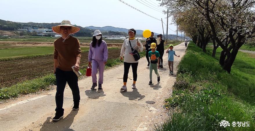 벚꽃길을 마을사람들이 걷고 있다