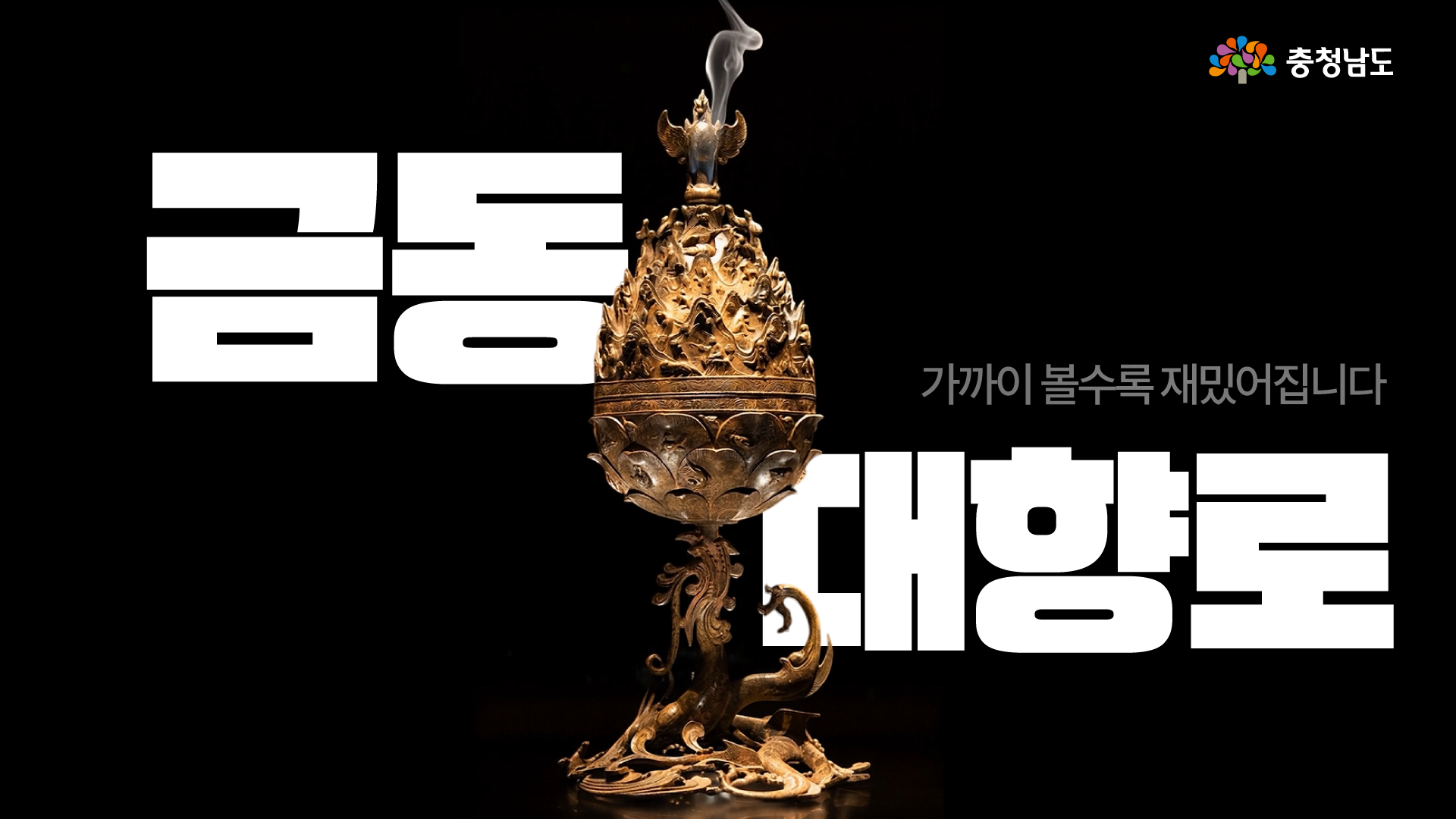 검은 가로형 배경 중앙에 향연이 피어오르는 백제 금동대향로가 세로로 놓여 있으며, 왼쪽에는 큰 흰색 글씨로 &ldquo;금동&rdquo;, 오른쪽에는 &ldquo;대향로&rdquo;가 배치되어 있습니다. 오른쪽 위에는 &ldquo;가까이 볼수록 재미있어집니다&rdquo;라는 문구가 있고, 오른쪽 상단 모서리에는 충청남도 로고가 표시되어 있습니다.