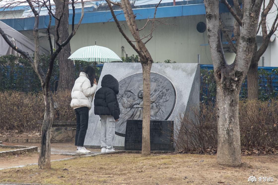 엄마와 함께 기념 조형물을 보고 있는 아이의 모습