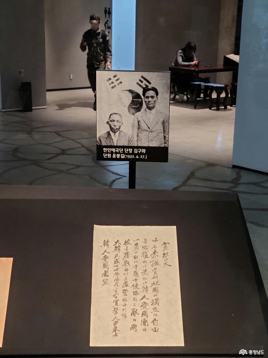 태극기 앞에 왼쪽에 김구 선생님께서 앉아계시고 오른쪽이 윤봉길 의사께서 서계십니다.