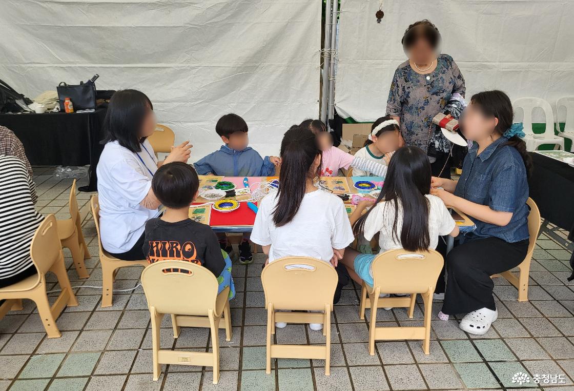 키링을 만들기 위해 앉아 있는 아이들과 선생님.