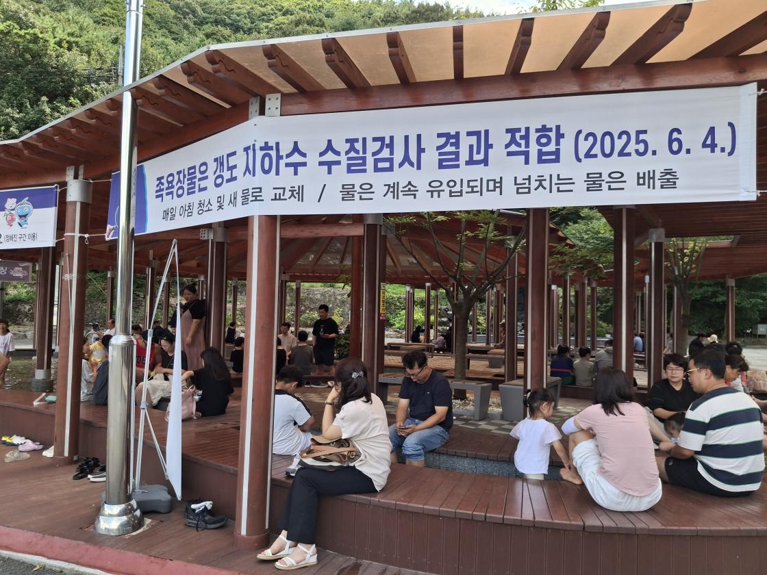 족욕장 모습(현수막 : 족욕장물은 갱도 지하수 수질검사 결과 적합(2025.6.4.) | 매일 아침 청소 및 새 물로 교체 / 물은 계속 유입되며 넘치는 물은 배출