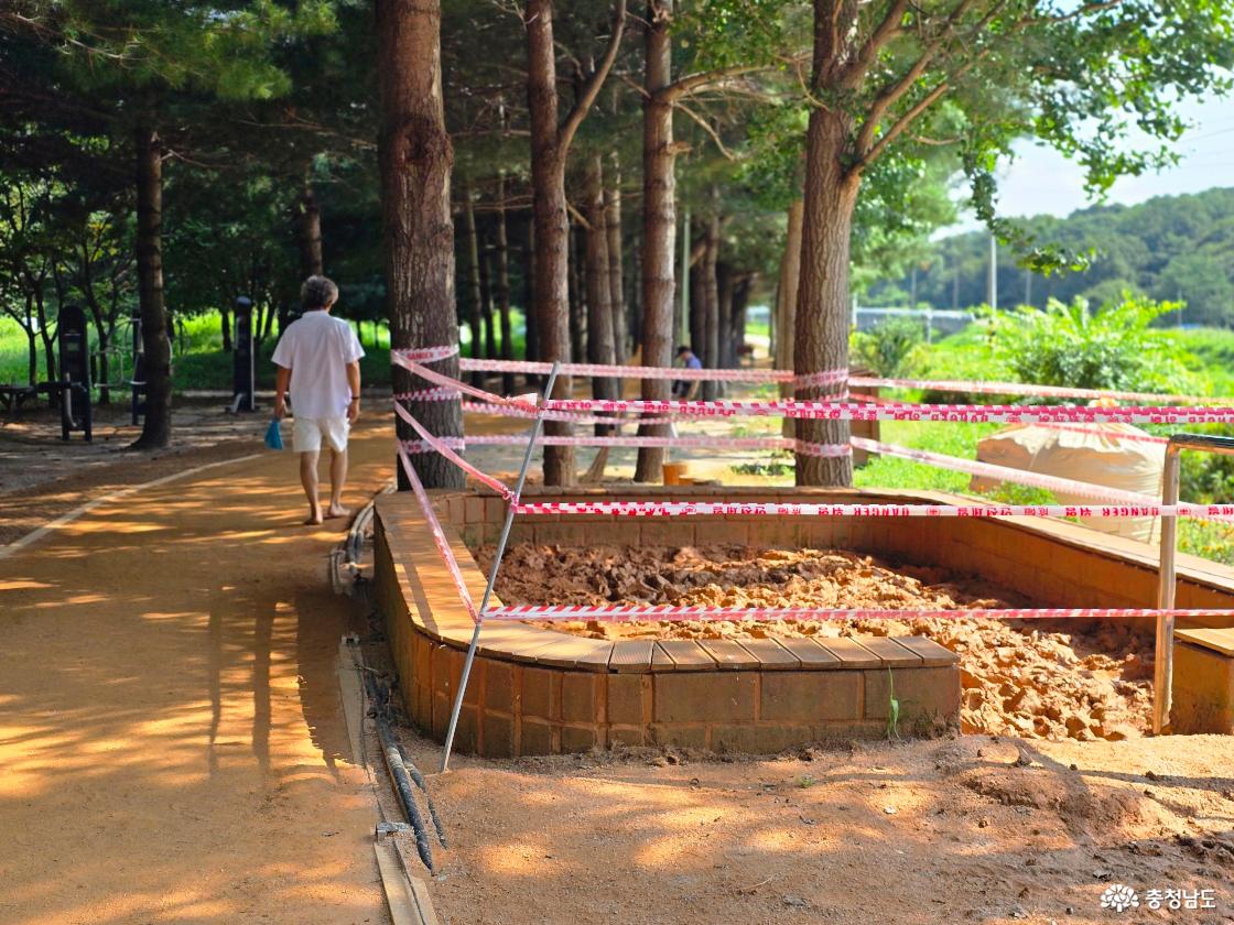 맨발황톳길을 걷는 행인과 공사중인 쉼터 사진입니다.