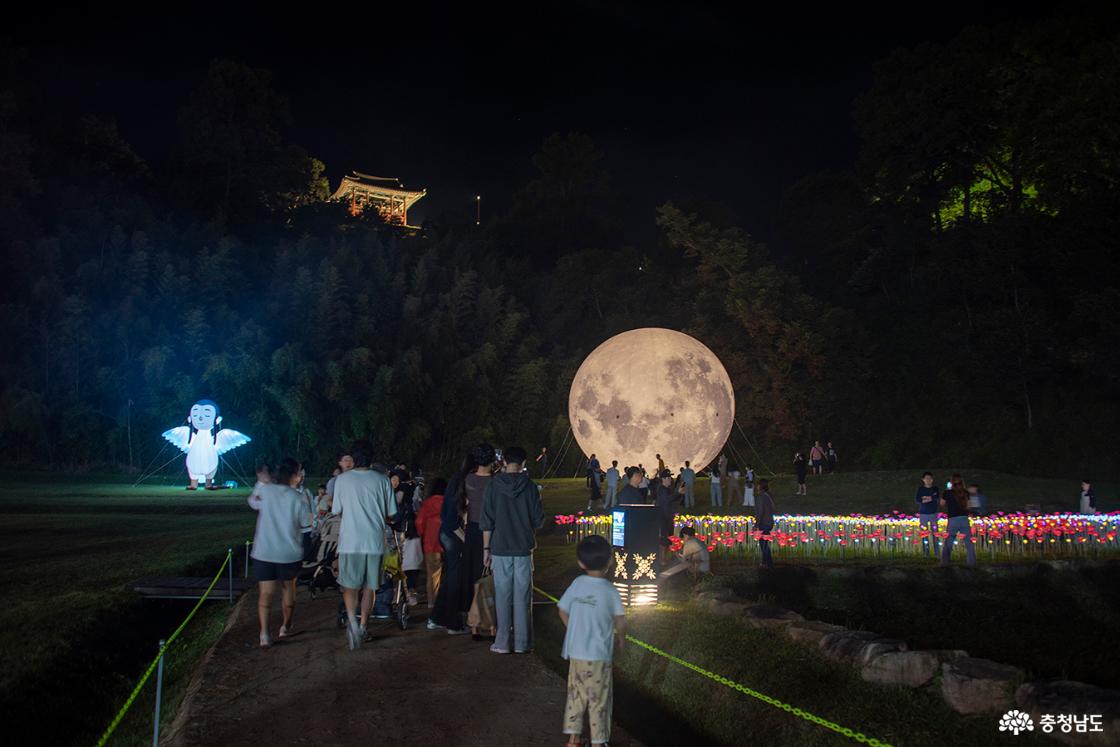 달 모형 앞에서 사진을 찍기 위해 기다리는 사람들