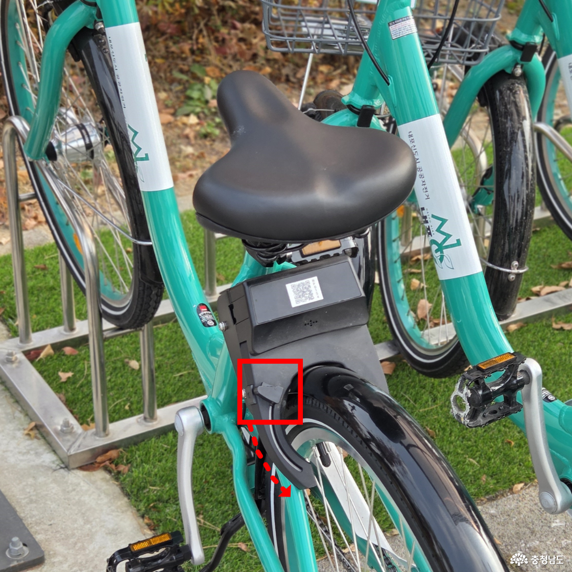 자전거 안장과 뒷바퀴 사이에 있는 잠금장치의 래버를 아래방향으로 내려 잠금을 해제합니다.