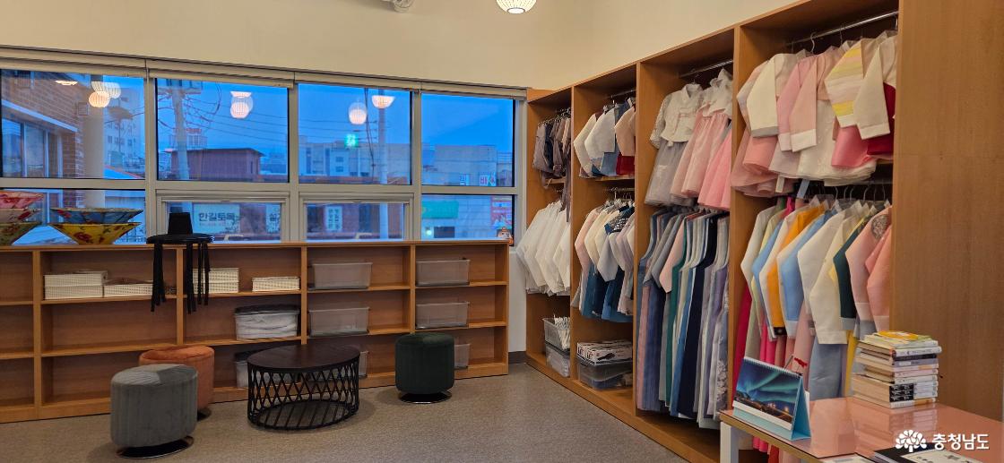 체험실 내부 우측의 모습입니다. 귀여운 아동용 한복과 단정한 성인 남성용 한복들이 종류별로 깔끔하게 정리되어 있고, 테이블도 마련되어 있습니다.