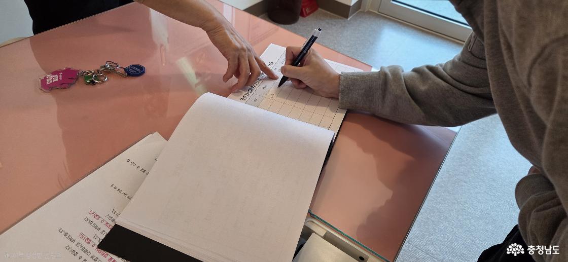 한복을 대여하기 전, 데스크에 마련된 이용 대장에 간단한 인적 사항을 기재하는 모습입니다. 성명, 전화번호, 거주지역, 대여물품 등을 적습니다.