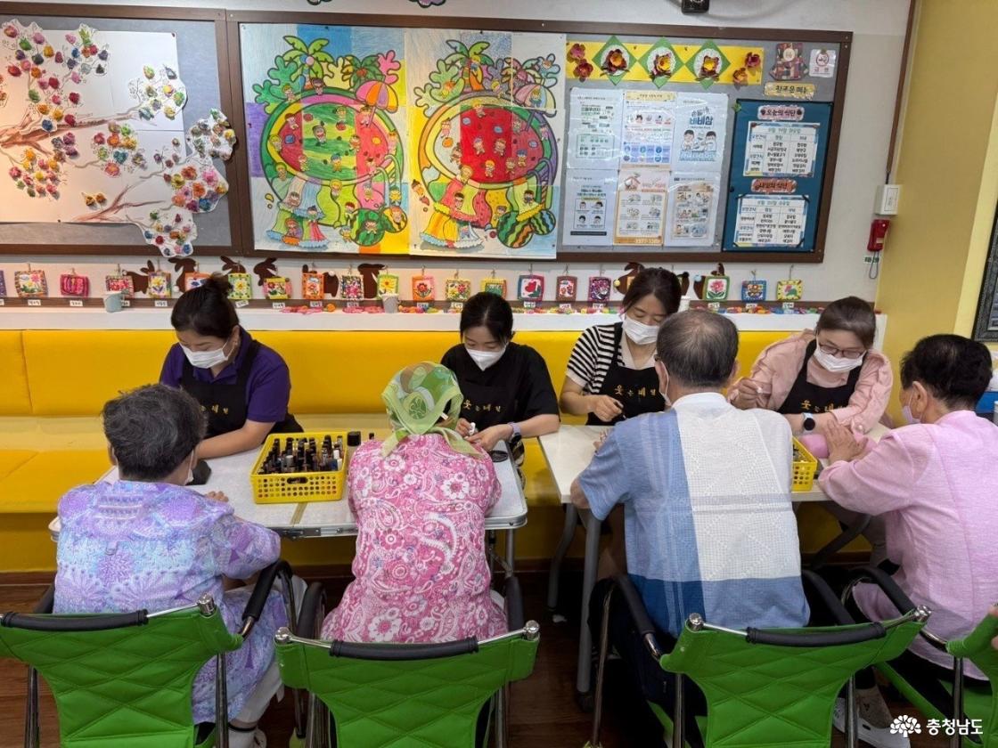 어르신들에게 네일아트를 하고 있는 봉사자들 
