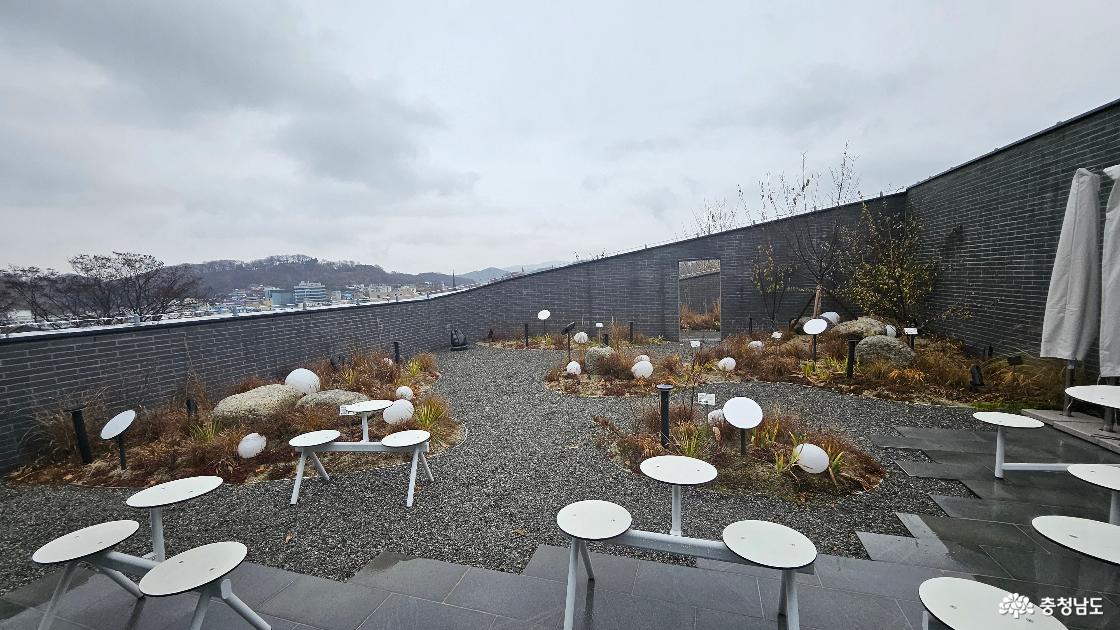 문학관 2층에 마련된 실외 공간 하늘마당 모습으로 야외 공간에 테이블이 여러 개 설치되어 있음