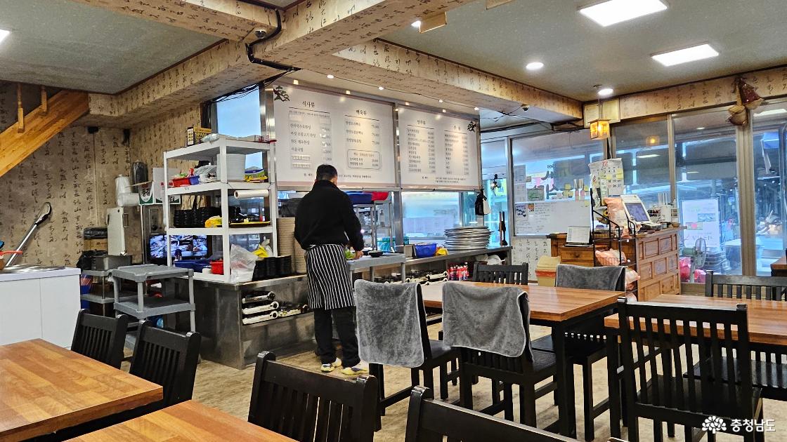 음식들을 서빙하려고 준비 중인 식당 직원의 뒷모습 사진임