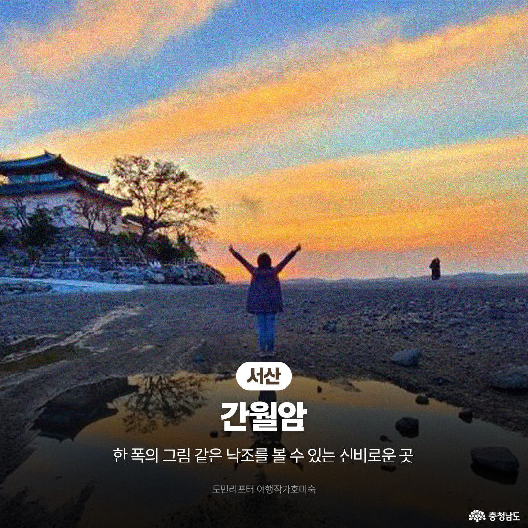 황금빛과 푸른빛이 오묘하게 섞인 하늘 아래, 바닷물이 들어찬 &lsquo;서산 간월암&rsquo;을 향해 한 여행객이 양팔을 벌리고 서 있는 뒷모습입니다. 물 위에 떠 있는 듯한 암자의 신비로운 분위기가 돋보이며, 한 폭의 그림 같은 낙조를 볼 수 있는 곳이라고 소개합니다.