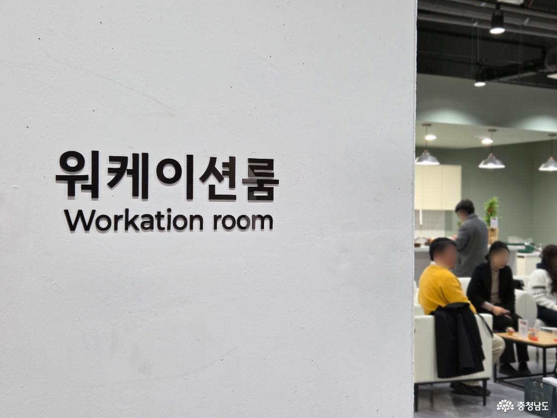 하얀 벽면에 검은 글씨로 '워케이션룸'이라고 적혀 있어요.