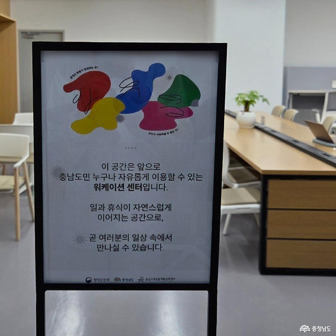 워케이션 센터 입구에 안내문이 세워져 있어요. '이 공간은 앞으로 충남도민 누구나 자유롭게 이용할 수 있는 워케이션 센터입니다. 일과 휴식이 자연스럽게 이어지는 공간으로, 곧 여러분의 일상 속에서 만나실 수 있습니다. (행정안전부 & 충청남도 & 충남지역공동체활성화센터)
