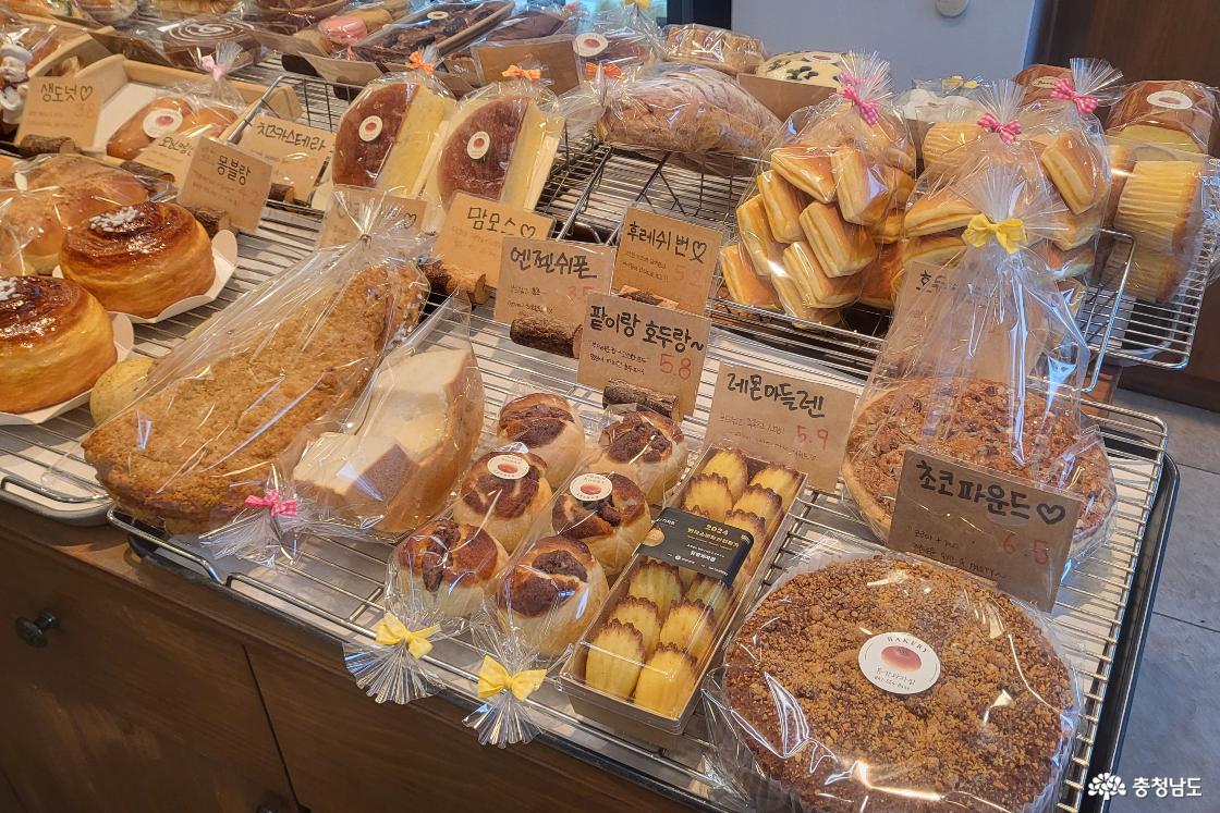 듀팡과자점 진열대에 몽블랑, 맘모스, 팥이랑 호두랑(호두파이), 레몬마들렌, 초코파운드 등 다양한 빵이 진열되어 있는 모습.