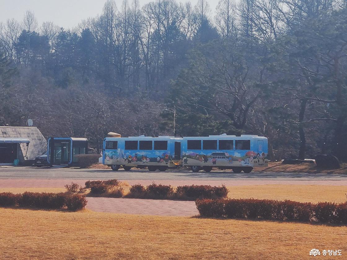 숲을 배경으로 운행 중인 독립기념관 관람 순환버스 모습