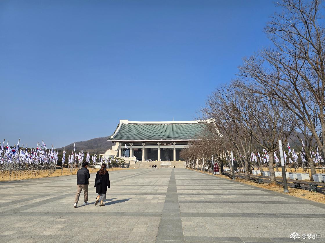 태극기 깃발이 늘어선 광장을 지나 독립기념관 본관으로 이어지는 산책로