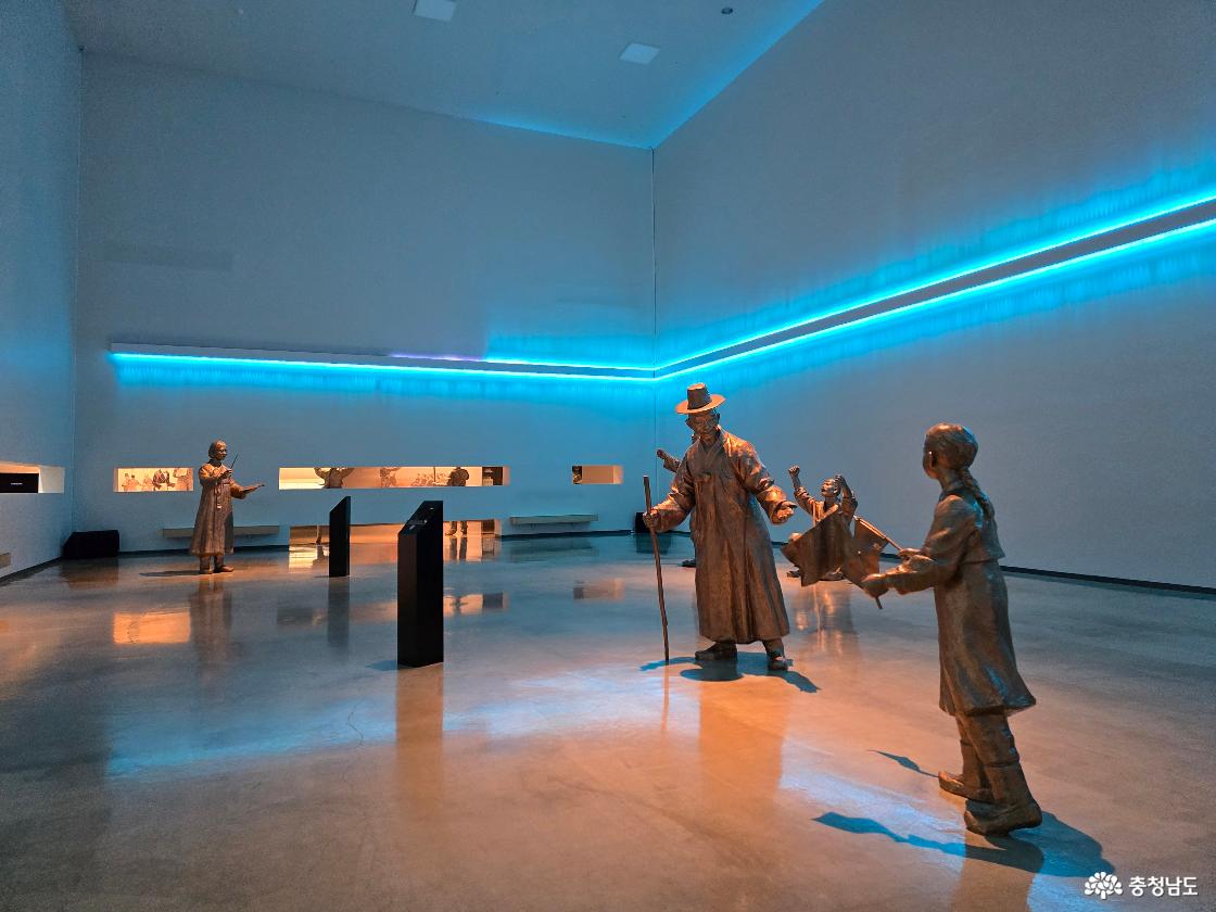 푸른 조명이 흐르는 전시실에서 3&middot;1운동을 재현한 인물 조형물 전경