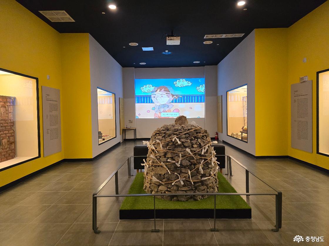 역사 교육 영상이 상영되는 전시 공간과 돌탑 전시물