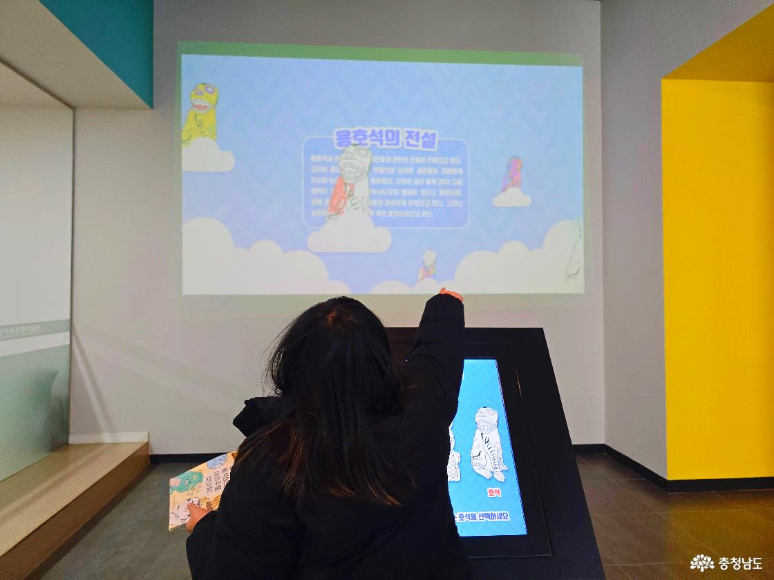 금산역사문화박물관 어린이 체험 전시에서 &lsquo;용호석의 전설&rsquo; 영상을 보며 인터랙티브 화면을 체험하는 어린이 모습