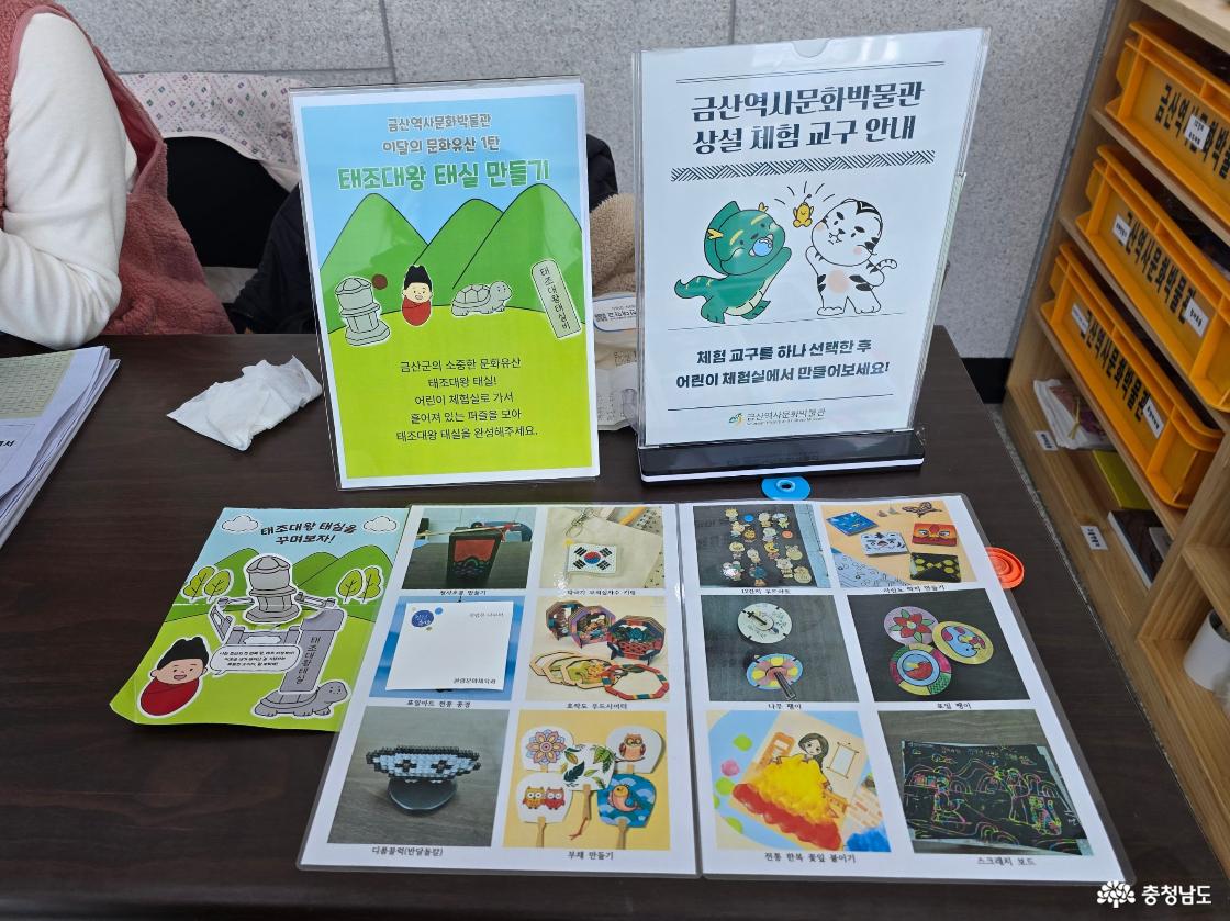 금산역사문화박물관 체험 안내 데스크에서 태조대왕 태실 만들기와 다양한 어린이 체험 프로그램을 소개하는 안내판과 체험 교구 안내 모습