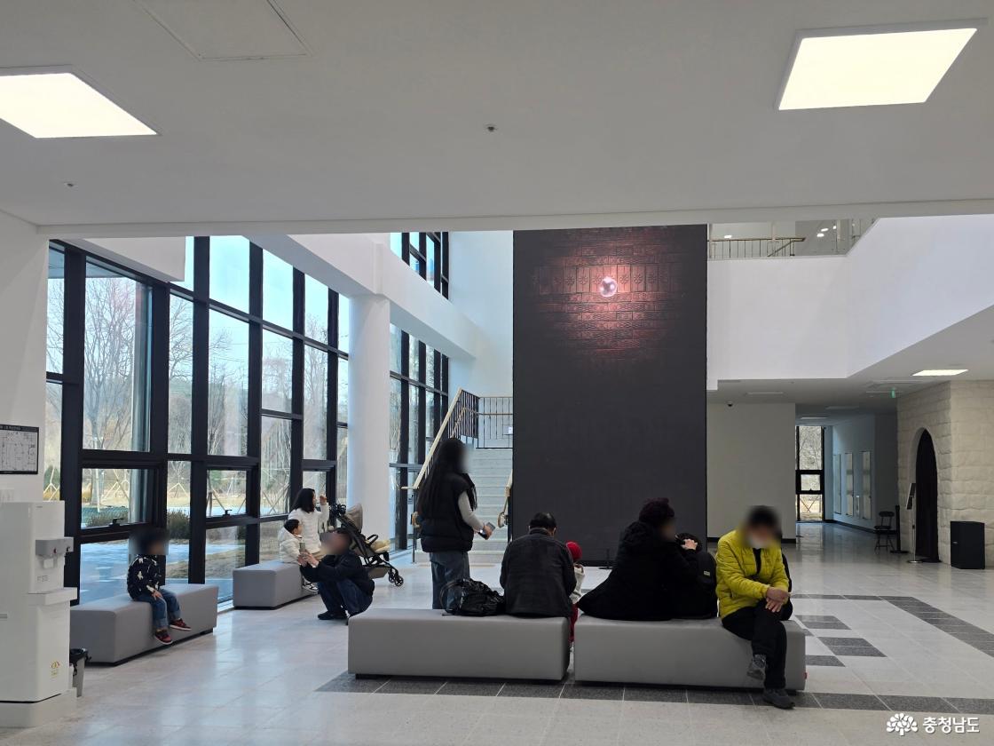 백제문화전당 로비 내부 전경과 방문객들이 휴식하고 있는 모습