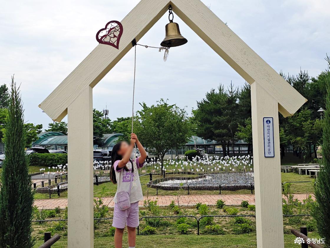 아산시 시설관리공단 사랑의 종 포토존에서 종을 울려보는 어린이 모습