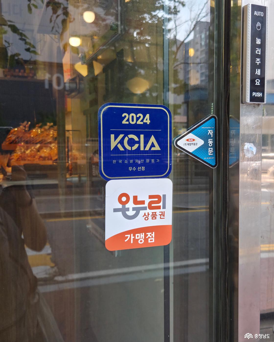 입구에 2024 KCIA 한국소비자산업평가 우수 선정 스티커와 온누리상품권 가맹점 안내 스티커가 나란히 부착되어 있습니다.