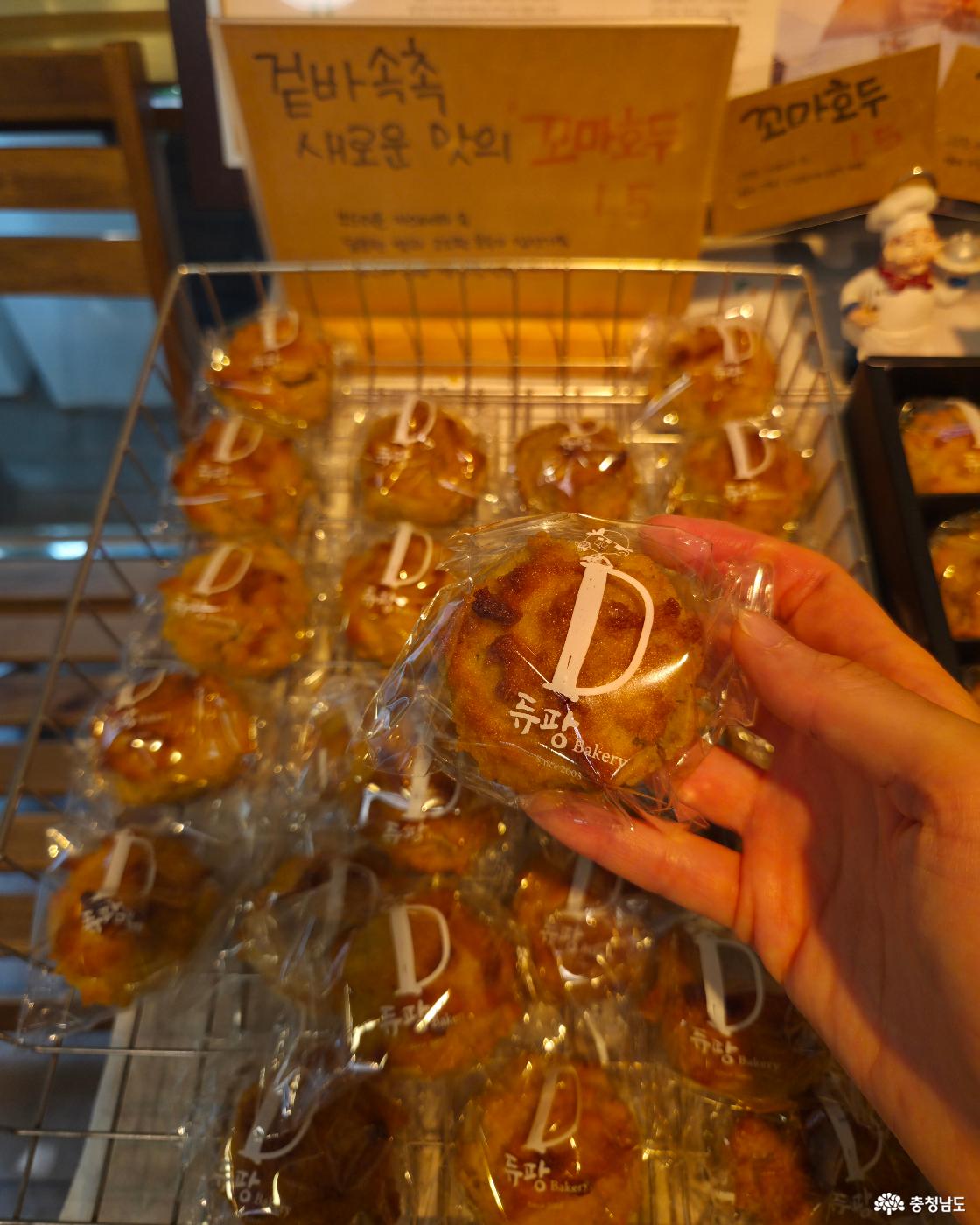 비닐 포장된 '꼬마호두' 빵을 집어든 모습입니다. 크기는 손보다 조금 작고 살짝 울퉁불퉁한 동그란 모양입니다.
