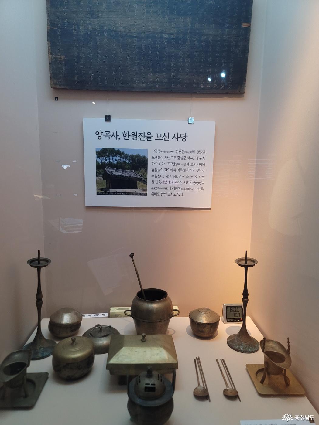 양곡사와 한원진을 소개하는 설명판 아래 촛대와 제기, 수저 등 금속 기물을 전시한 진열장