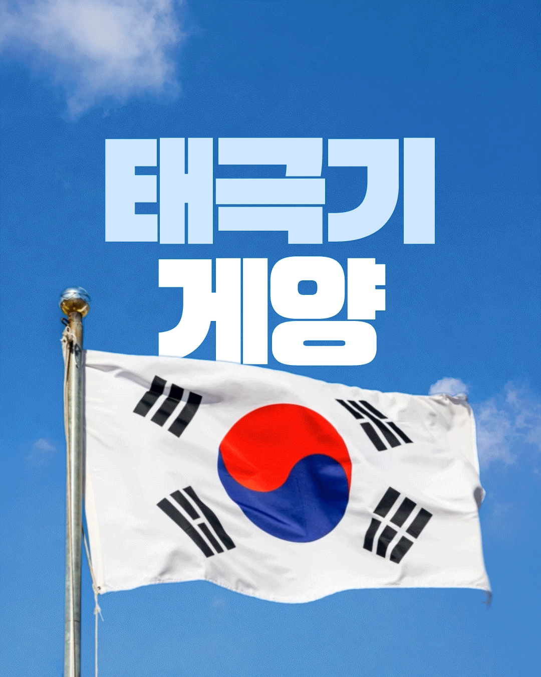 파란 하늘과 흰 구름을 배경으로 깃대에 걸린 태극기가 바람에 크게 펄럭이는 모습을 담았으며, 화면 위쪽에는 흰색 대형 글씨로 &lsquo;태극기 게양&rsquo;이라고 적혀 있습니다. 태극기의 흰 바탕 중앙에 빨강&middot;파랑 태극 문양과 네 모서리의 검은 건곤감리 4괘가 선명하게 보입니다.