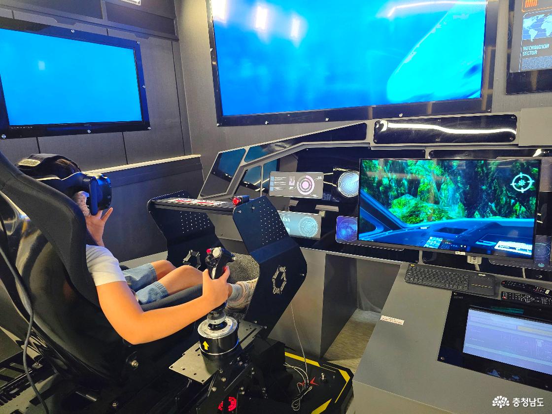 VR 헤드셋을 착용하고 조이스틱으로 전투기 체험을 하는 어린이