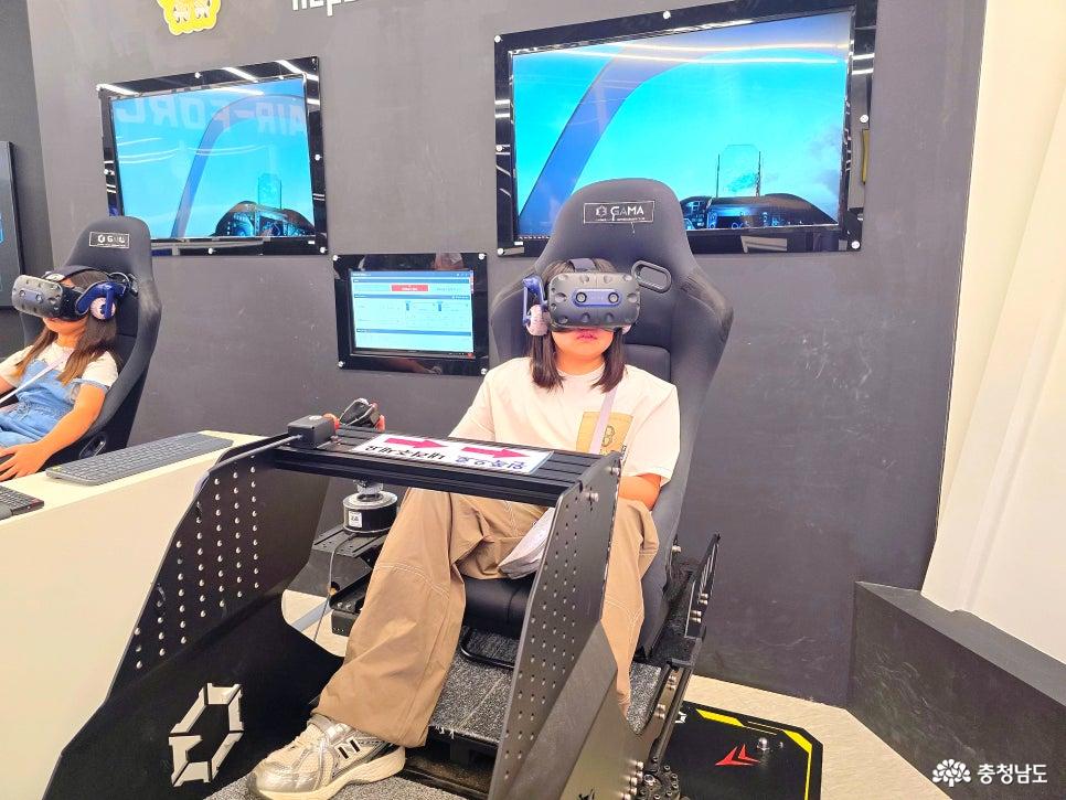 VR 헤드셋을 착용하고 전투기 조종 장치에 앉아 있는 어린이
