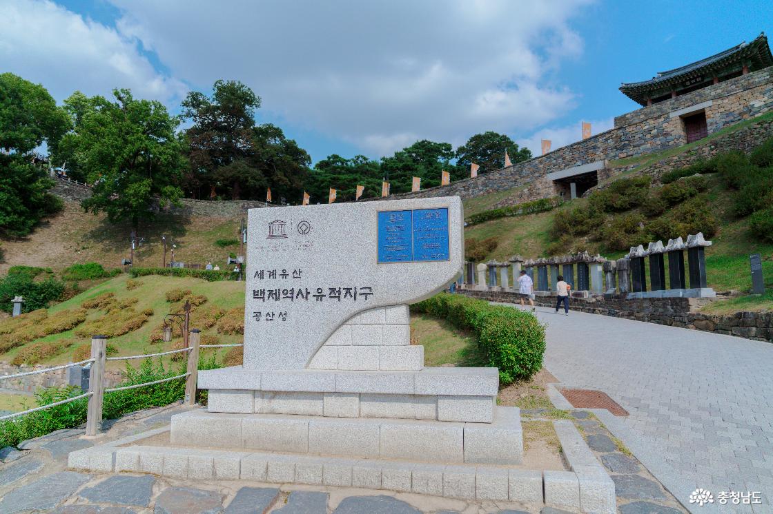 세계유산 백제역사유적지구 공산성 표지석. 뒤편 언덕의 금서루와 성벽, 진입로 옆에 나란히 세운 비석들.