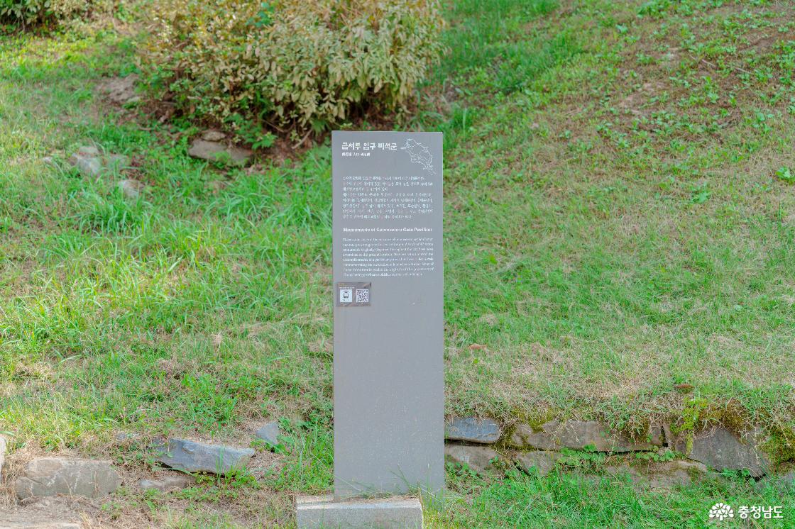 공산성 금서루 입구 비석군 안내판. 풀로 덮인 경사면 앞에 세운 회색 안내판의 한글·영문 설명과 QR코드.