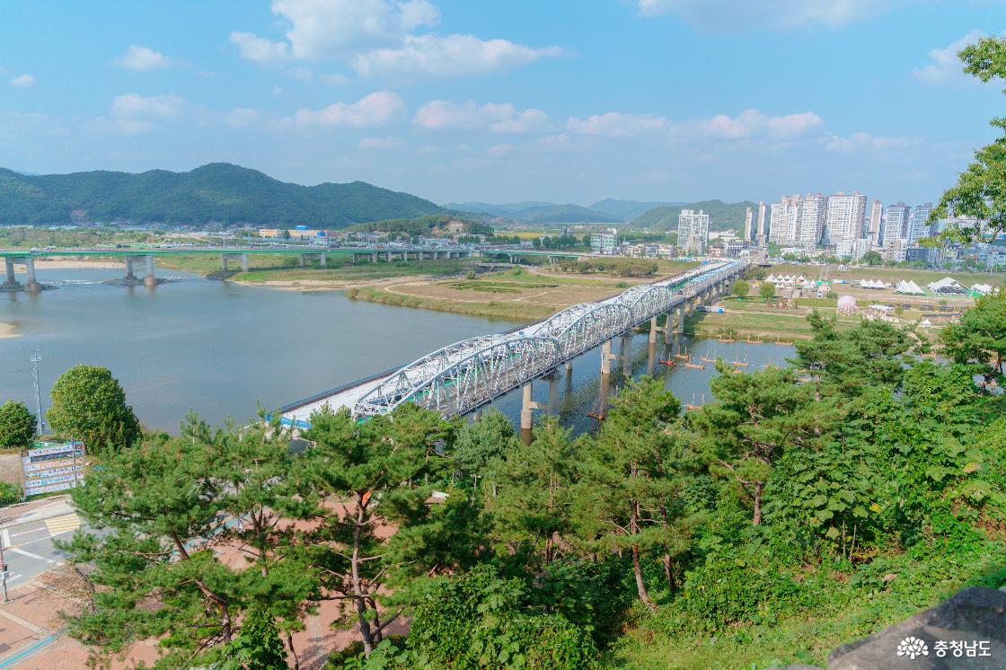 공산성에서 내려다본 금강과 금강철교. 강 건너 축제 천막이 설치된 넓은 공원과 아파트 단지, 멀리 산줄기.