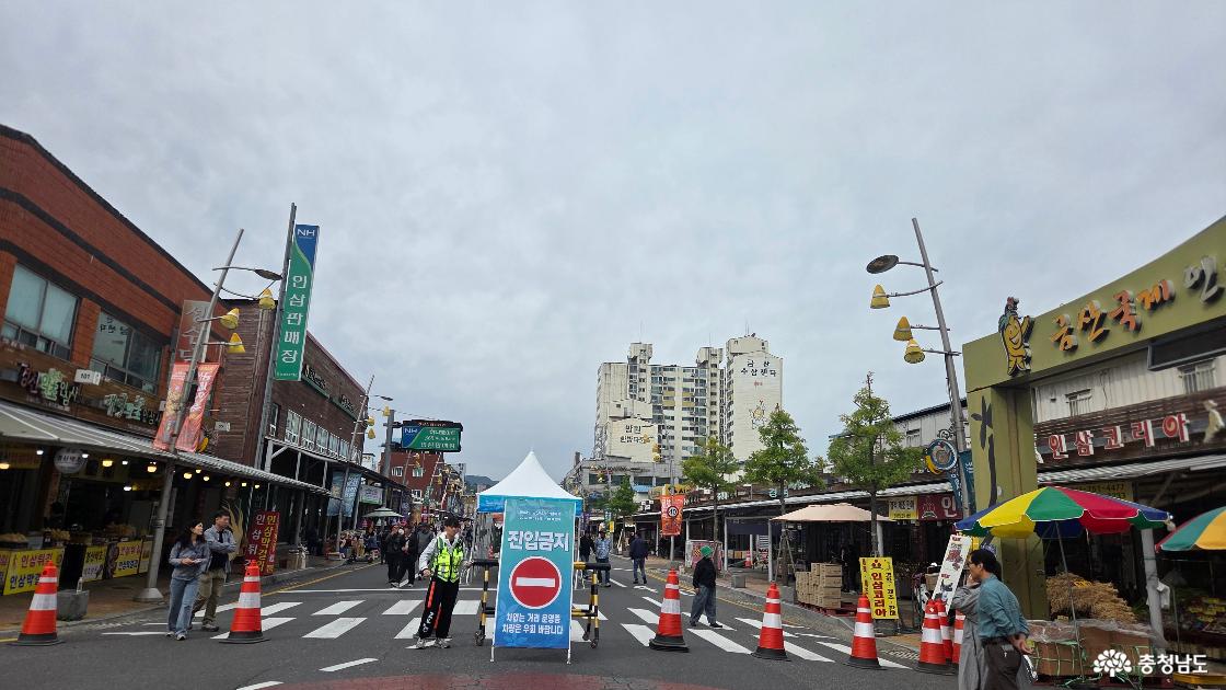 금산국제인삼시장 앞 도로의 차량 진입금지 안내판과 안전요원, 시장을 오가는 방문객들